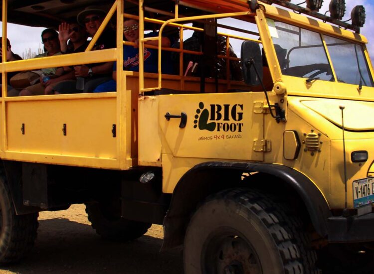 Bright yellow safari truck with people aboard