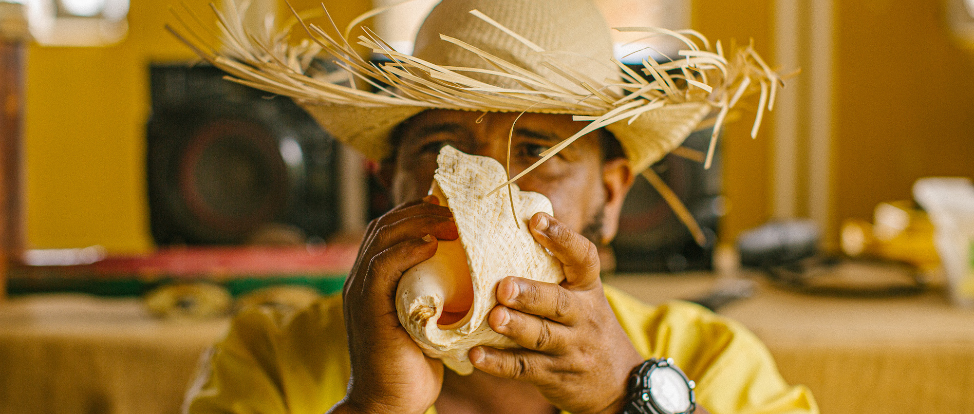 Woman blowing into conch shell