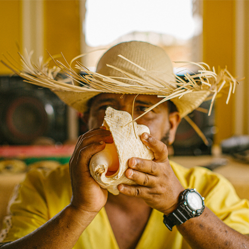 Male blowing in conch shell