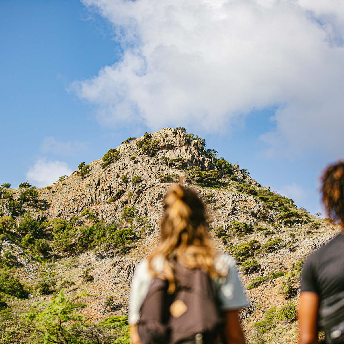 Woman and man hiking up a hill