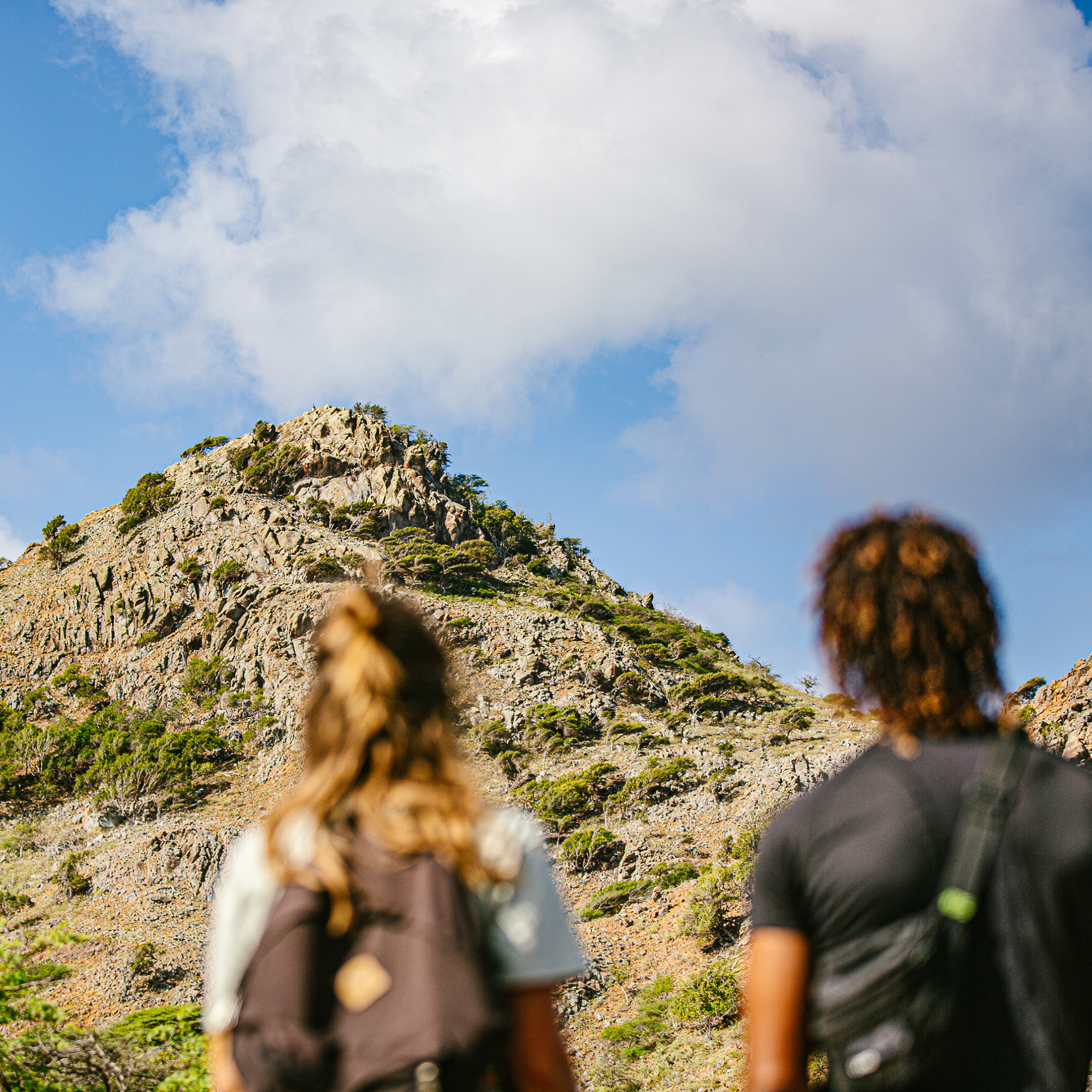 Man and woman looking up at mountain view