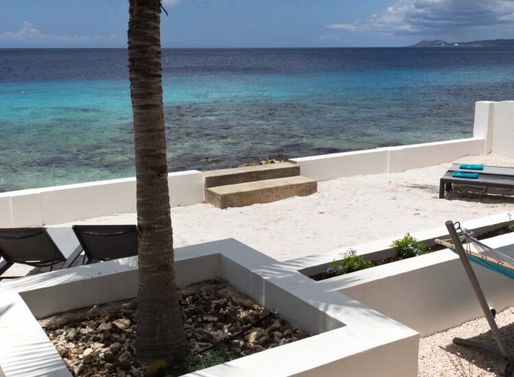 Outdoor lounge area by the ocean with chairs and hammock