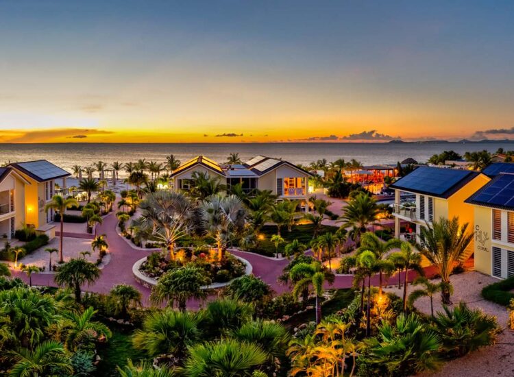 Panoramic view of hotel property with view of the ocean during sunset