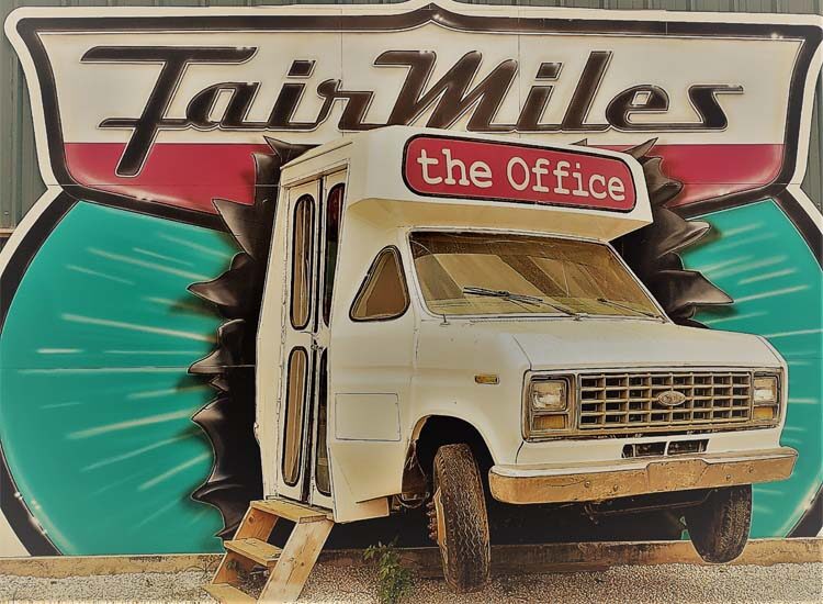 Close up shot of business' logo of a van crashing through a highway sign