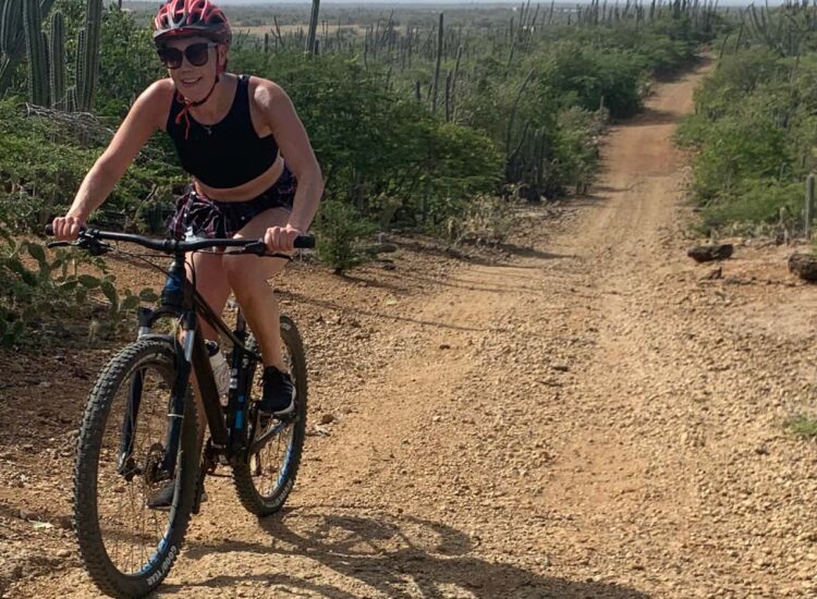 Woman biking on a dirt road