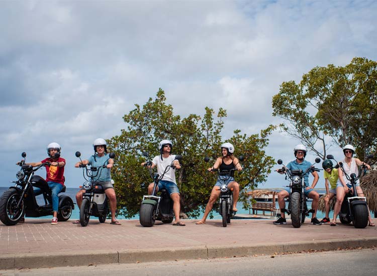 Multiple people on bikes by the ocean
