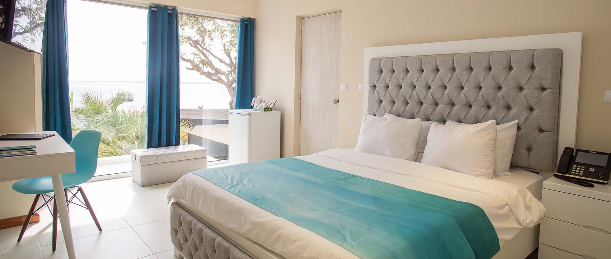 Hotel room with large bed, desk, and an ocean view