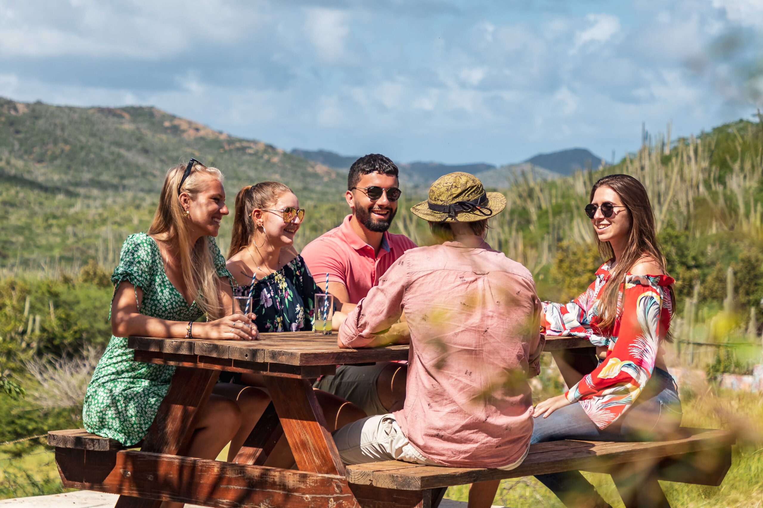 Group of people sitting on table waiting for food in bonaire