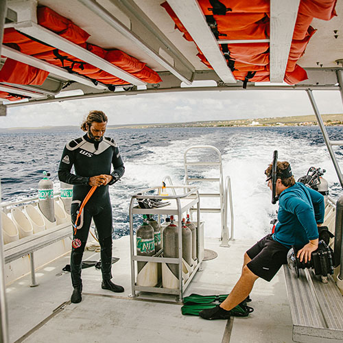 Two men coming out of the water in scuba gear