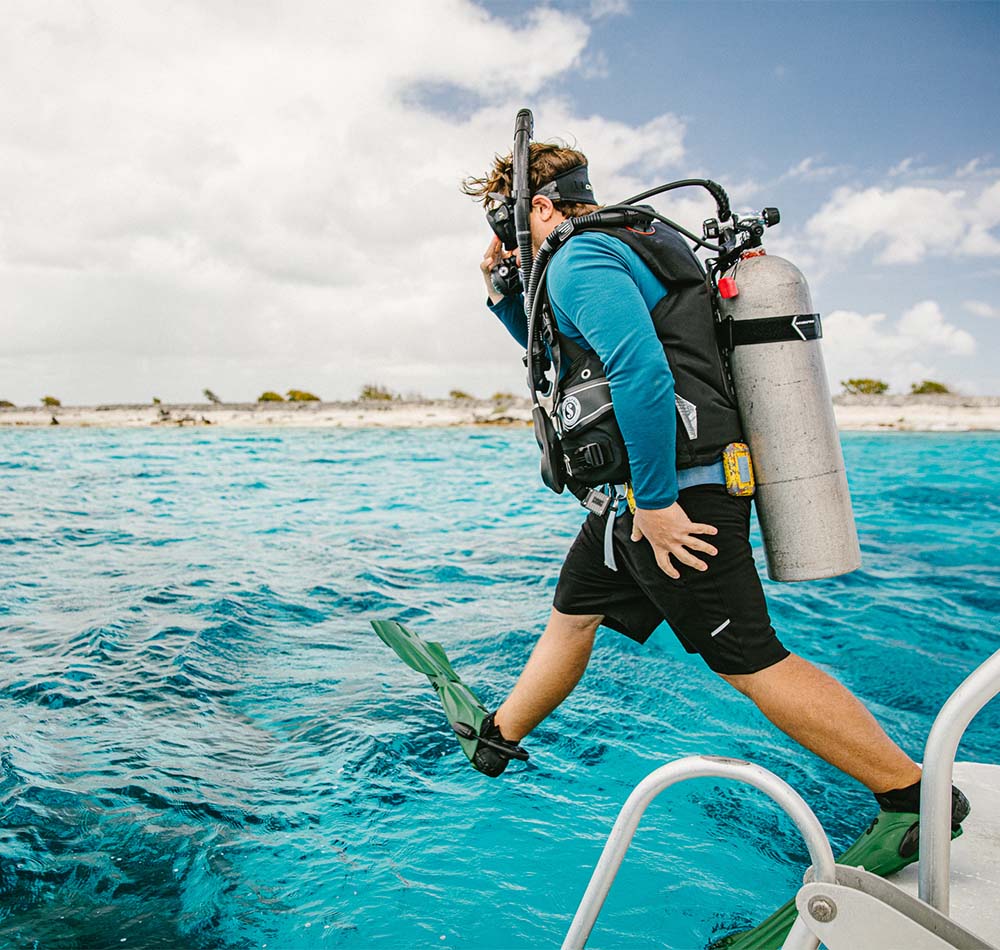 Diver jumping into ocean from boat