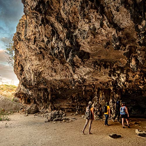 Group of people walking into an cave