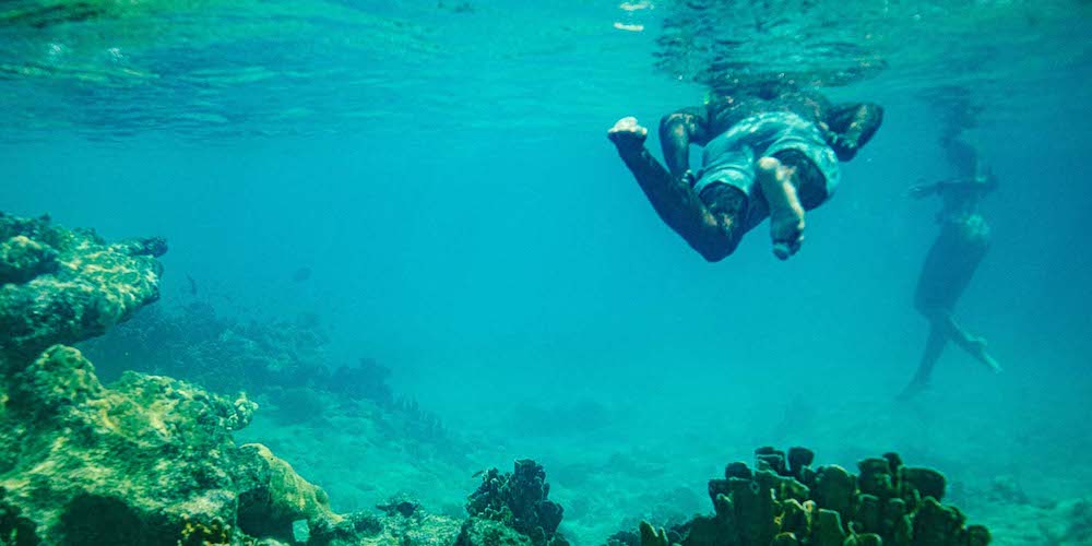 Underwater view of two swimmer and coral reef