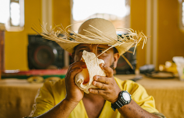 Man blowing into conch shell