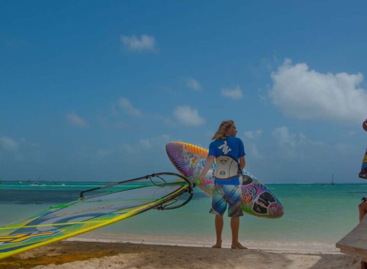 Mulitple people by the shore with surfboards
